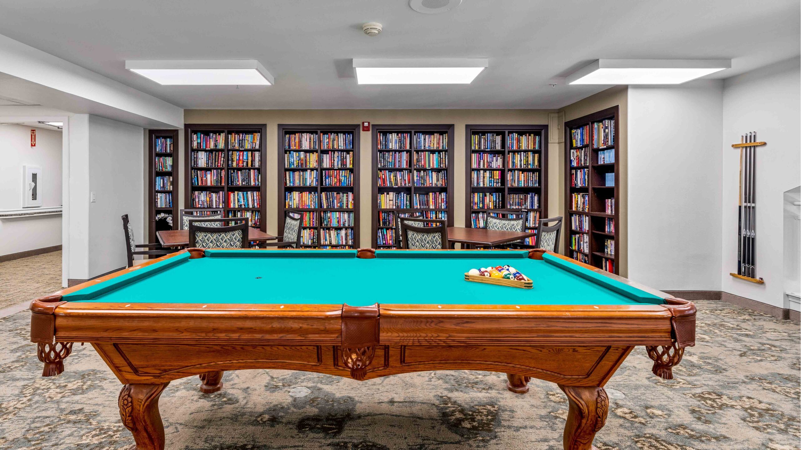 The library at Jordan Oaks with shelves of books and comfortable seating